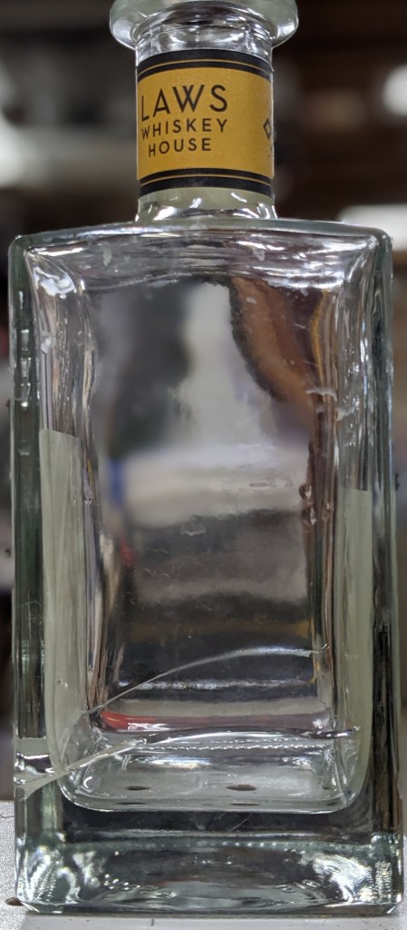 Cracks in both sides of a LAWS bourbon bottle.  