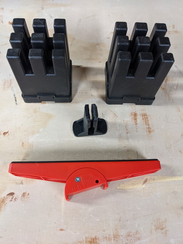 Clamp holders hold parallel clamps upright 90-degrees from one another. Red alternate clamp-end accommodates non-parallel pieces.
