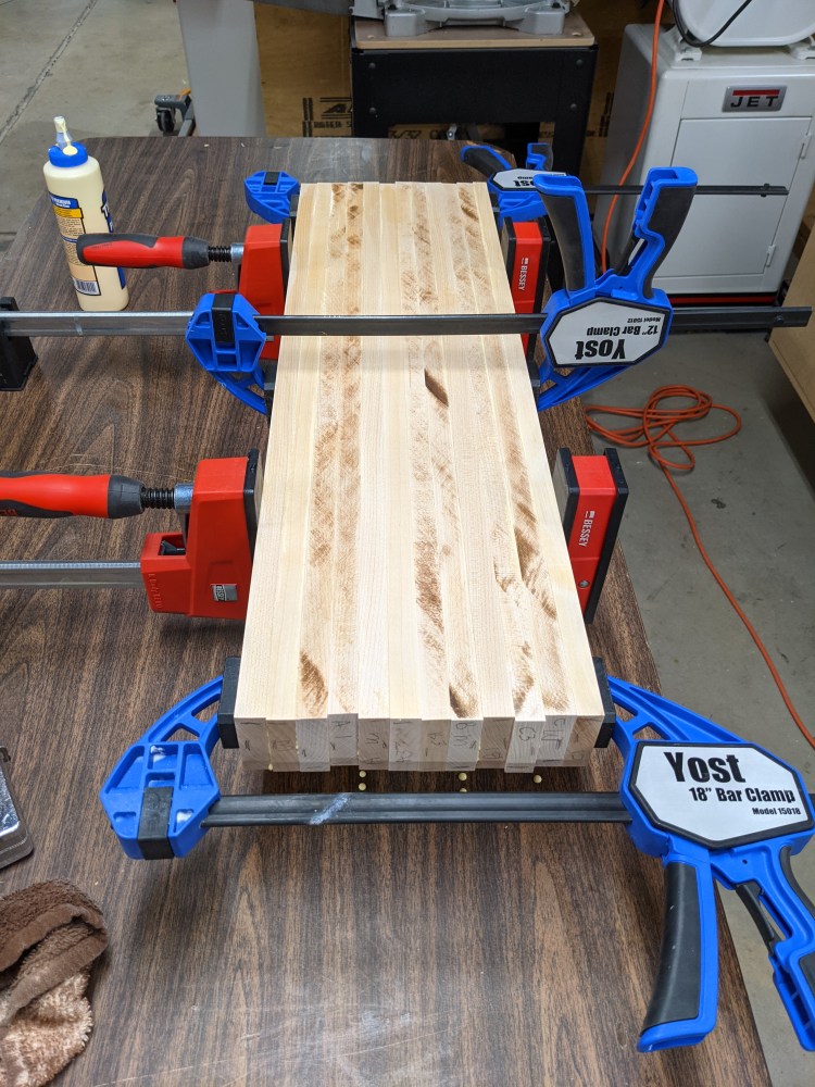 The Red Parallel clamps ensure alignment before added pressure is applied with the bar clamps (blue).